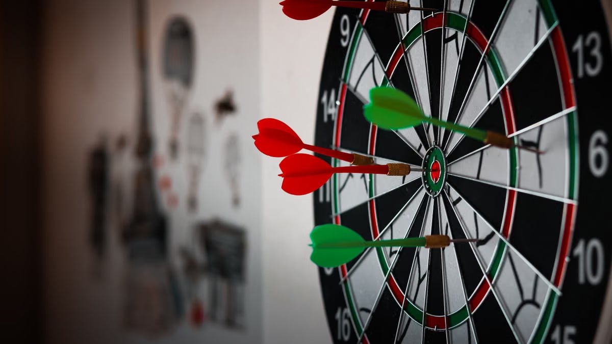 Close-up of a dartboard with multiple darts hitting the target, emphasizing precision and focus.